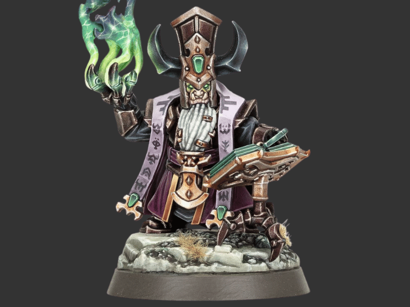 A painted fantasy miniature figurine of a horned scholar wizard holding an open book and casting a green magical glow, set against a solid dark gray background.
