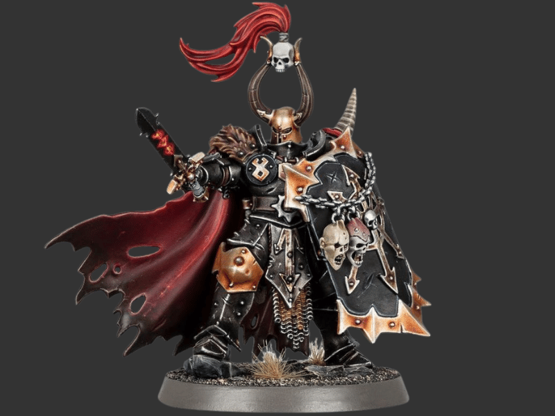 A detailed fantasy warrior miniature figurine with black and bronze armor, a flowing red cape, skull decorations, and a horned helmet, standing on a circular base against a dark gray background.
