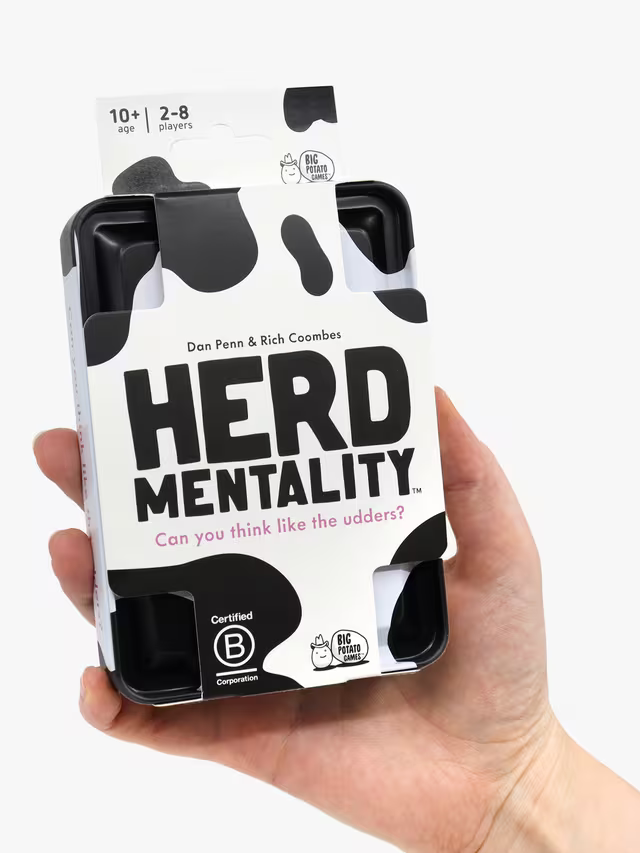 Hand holding the pocket-sized Herd Mentality travel tin to show its compact size