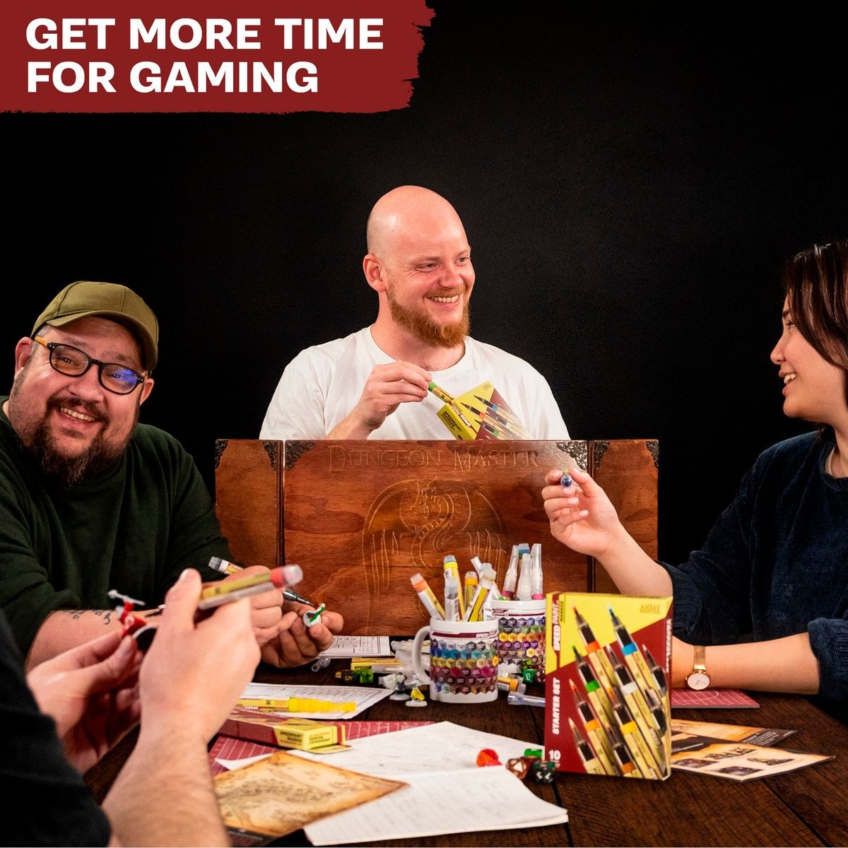 Hobbyists painting miniatures with Speedpaint Markers around a gaming table