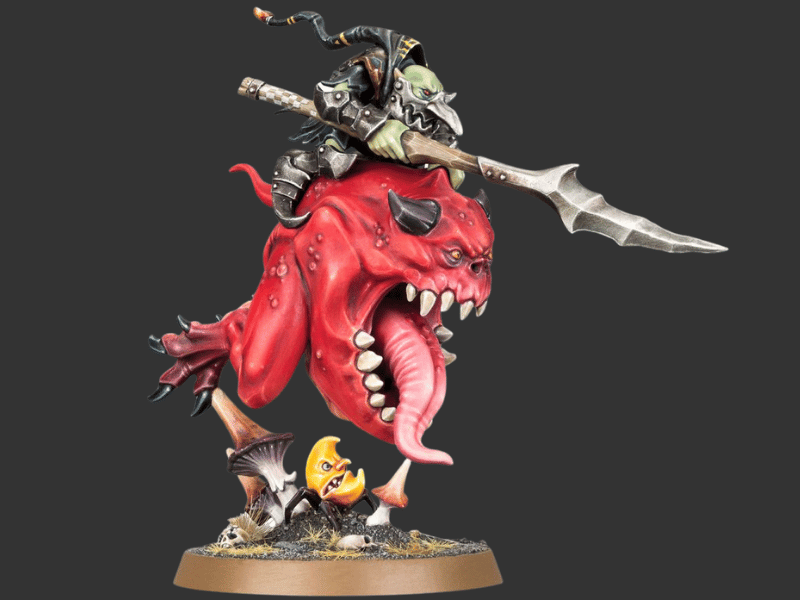A painted fantasy miniature figurine of a green-skinned warrior riding a red demonic beast, holding a large silver spear, mounted on a round brown base against a dark gray background.