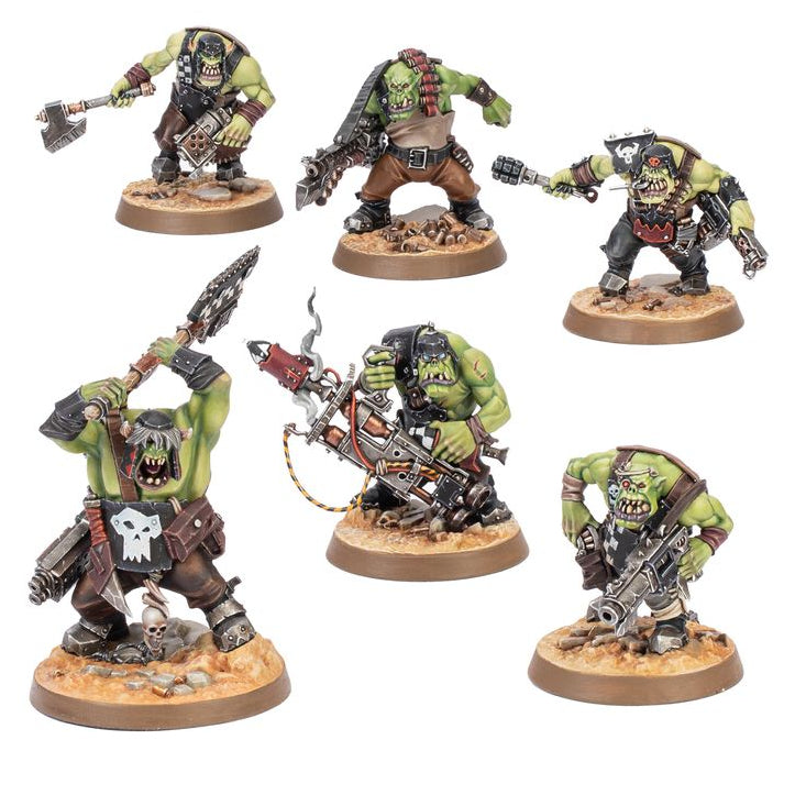 Five painted fantasy warrior miniatures on round brown bases, shown against a plain white background. The figures are green-skinned and heavily armored, with weapons including axes, chainsaws, and rifles.