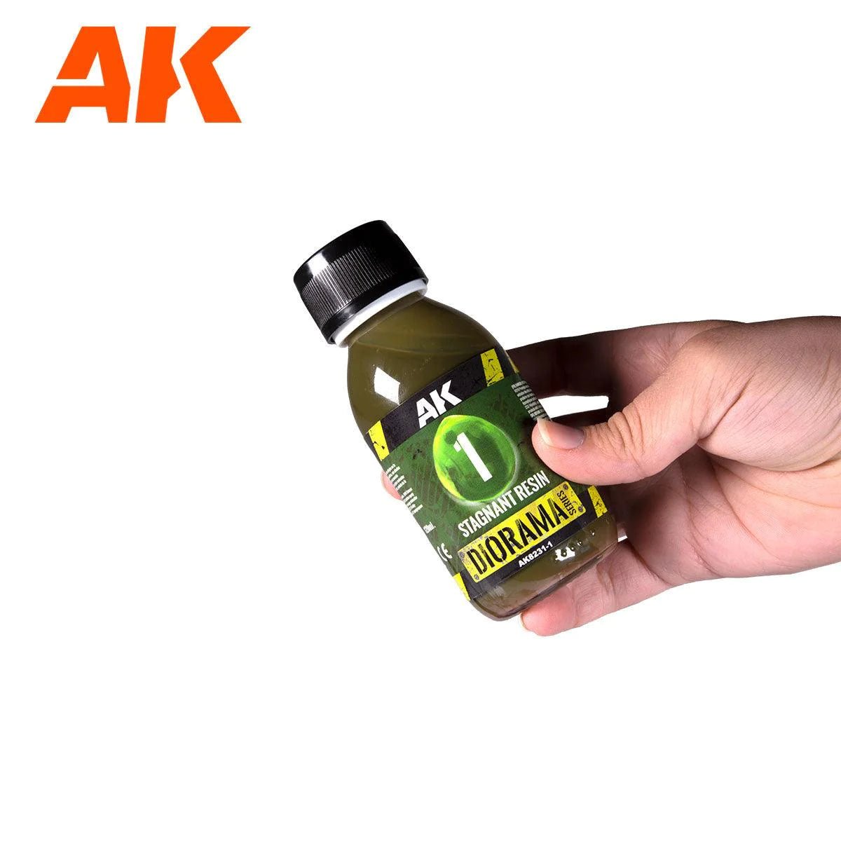 Hand holding a bottle of AK Interactive Standing Water epoxy resin for dioramas