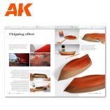 AK Realistic Wood Effects book spread on chipped paint over a red wooden hull