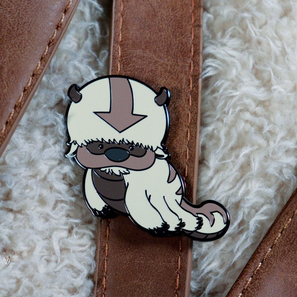 Avatar Appa pin badge fixed to a brown leather bag strap