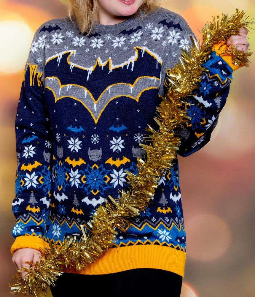 Woman holding gold tinsel wearing the Batman Frosty Christmas jumper with icy bat logo