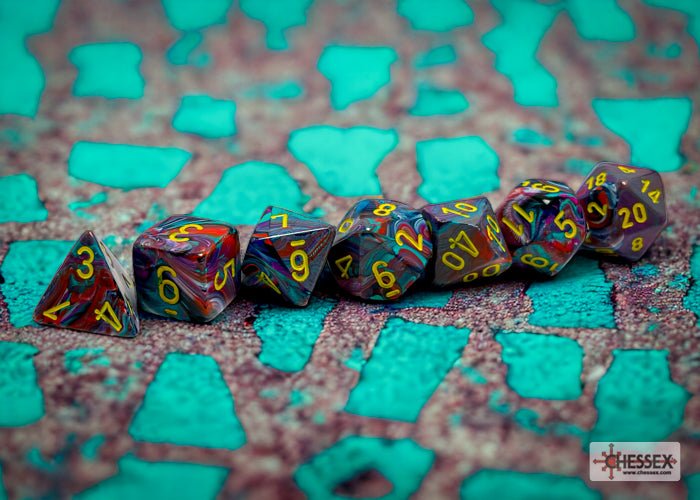 Chessex Festive Mosaic dice lined up in a row on a textured teal and grey surface