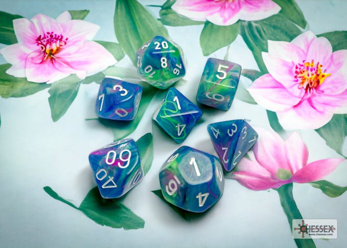 Chessex Festive Waterlily and White dice scattered among pink flowers