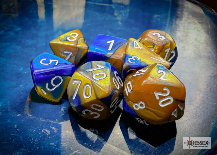 Chessex Gemini blue and gold swirled dice set on a blue glass surface