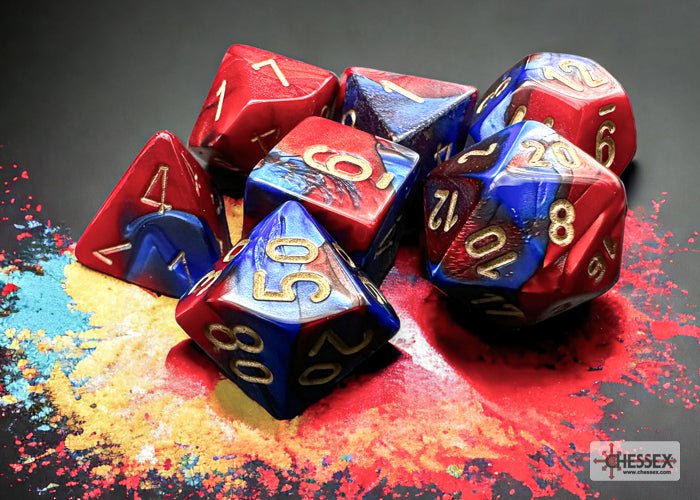 Chessex Gemini Blue-Red with Gold dice piled on a splash of coloured powder
