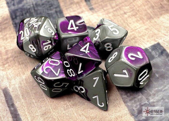 Chessex Gemini purple and steel grey swirled dice set on a patterned cloth