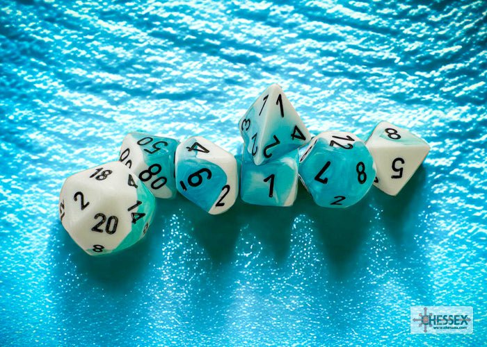 Chessex Gemini White-Teal polyhedral dice lined up on a rippled turquoise backdrop