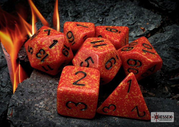 Chessex Speckled Fire 7 dice set on charred wood with flames behind