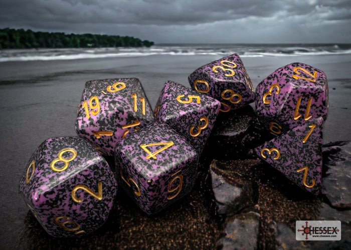 Chessex Speckled Hurricane dice set on a rocky shoreline beneath a stormy sky