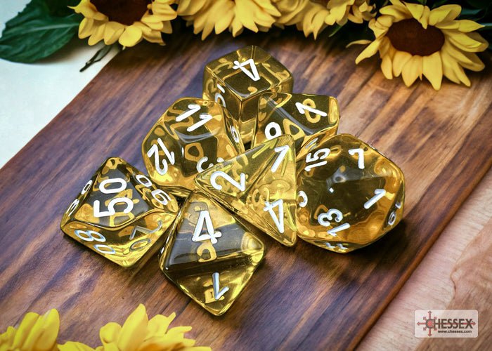 Chessex Translucent yellow dice set on a wooden board with sunflowers