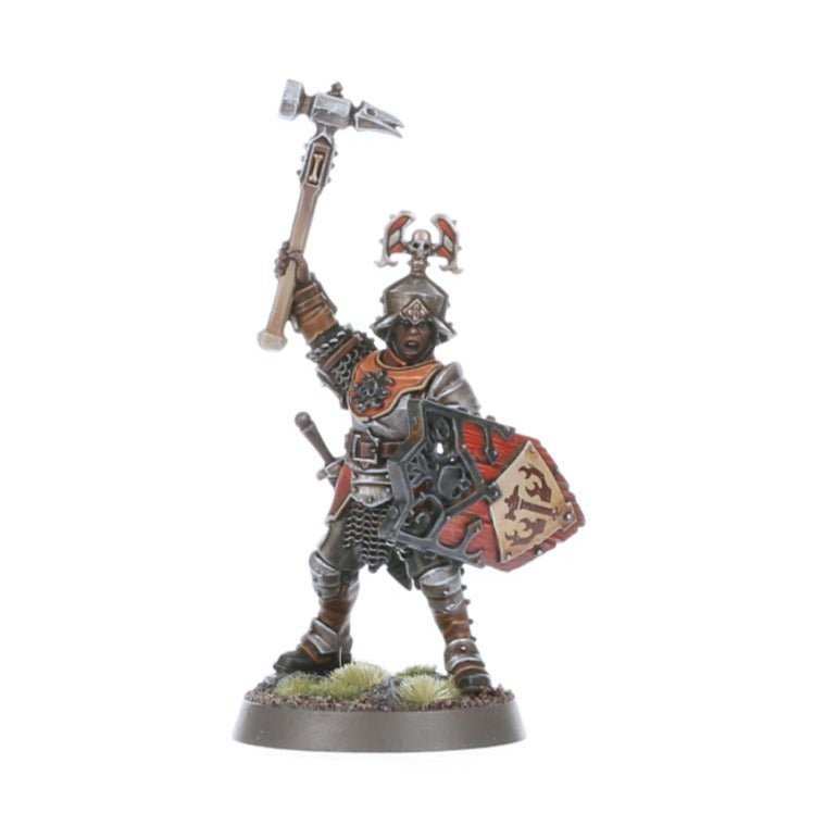 Painted Freeguild Steelhelm raising a warhammer behind a red heraldic shield