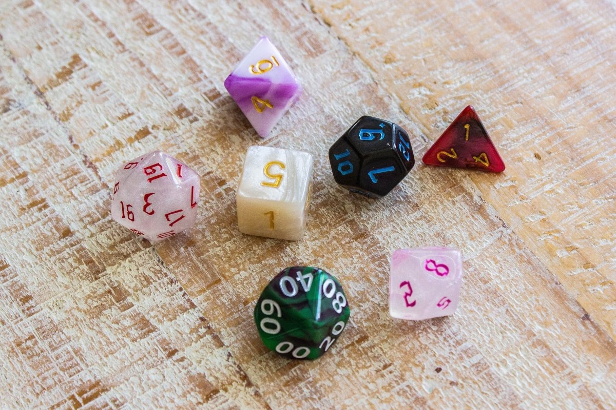 Dice Goblin mismatched polyhedral dice in pink, white, black, green and red, top view