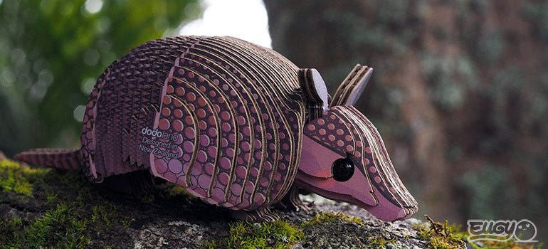 EUGY Armadillo card model sniffing along a mossy branch, close-up