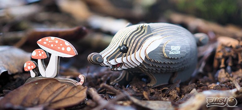 EUGY Badger card model on a woodland floor beside red toadstools