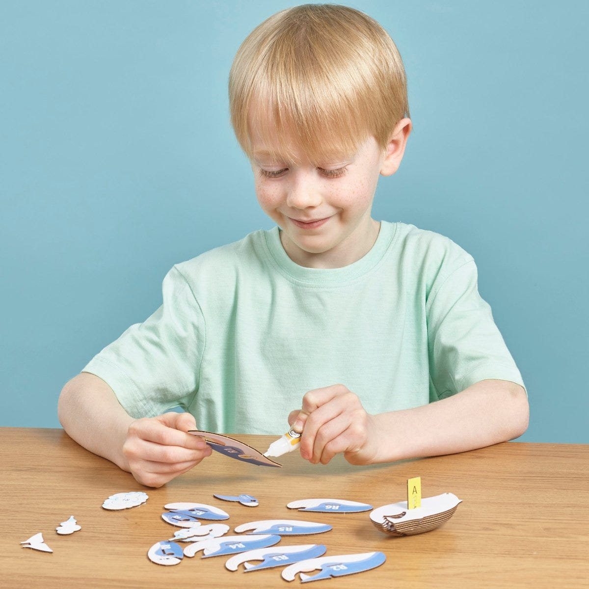 EUGY Blue Whale 3D cardboard model kit - child gluing the pieces