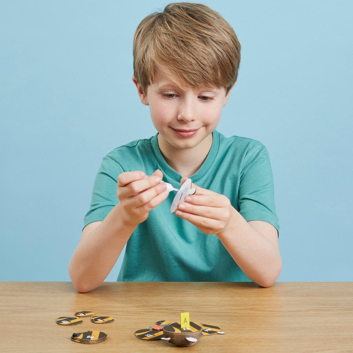 EUGY Bumblebee 3D cardboard model kit - child gluing the pieces