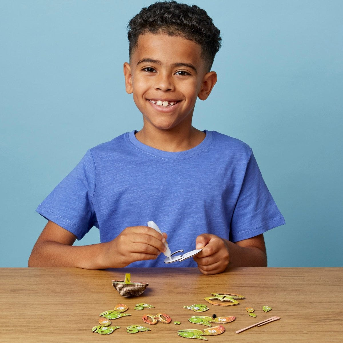 EUGY Chameleon 3D cardboard model kit - child gluing the pieces