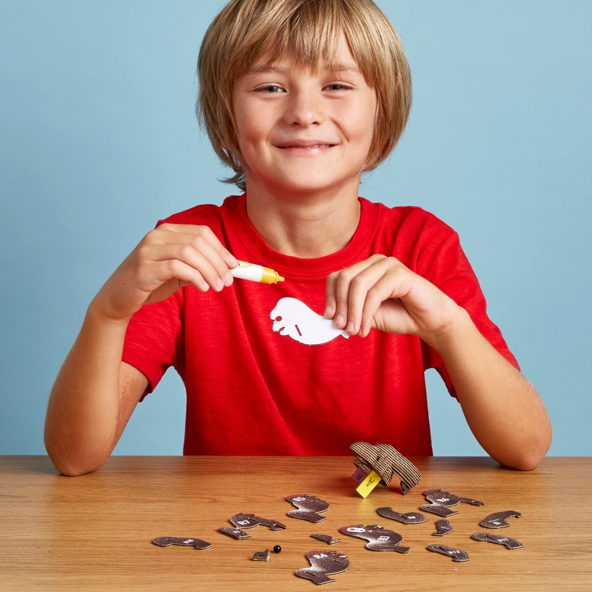 EUGY Gorilla 3D cardboard model kit - child gluing the pieces