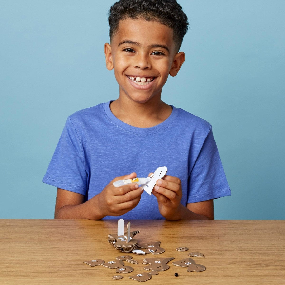 EUGY Kangaroo 3D cardboard model kit - child gluing the pieces