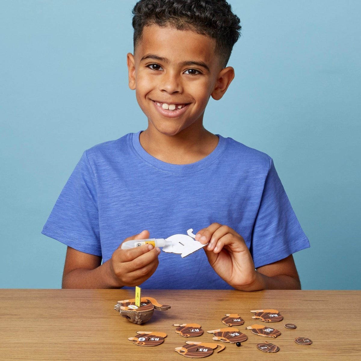 EUGY Lion 3D cardboard model kit - child gluing the pieces