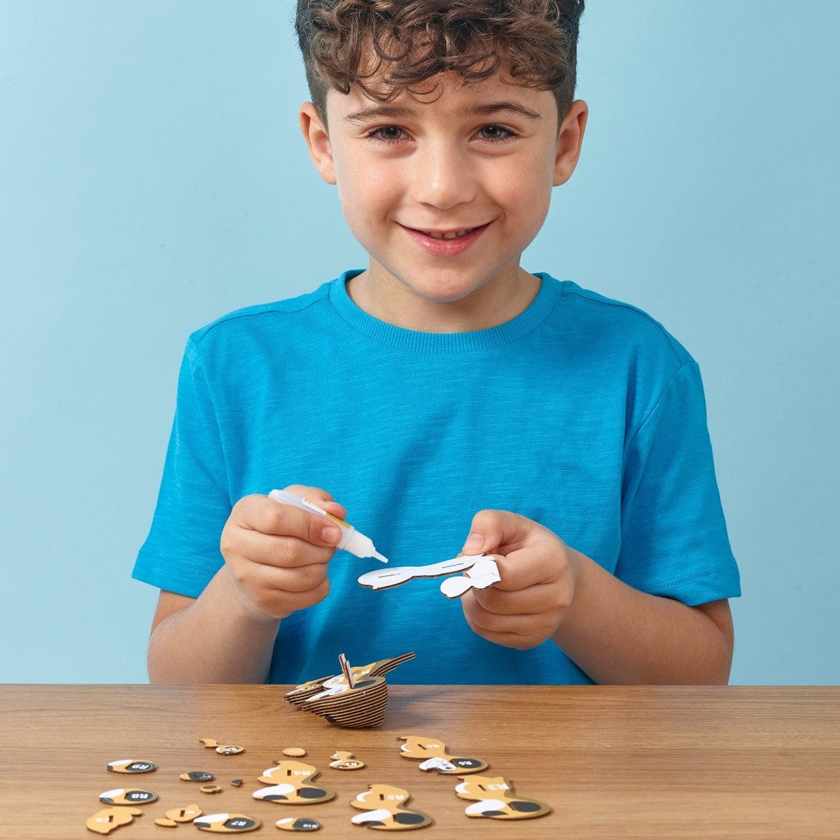 EUGY Meerkat 3D cardboard model kit - child gluing the pieces