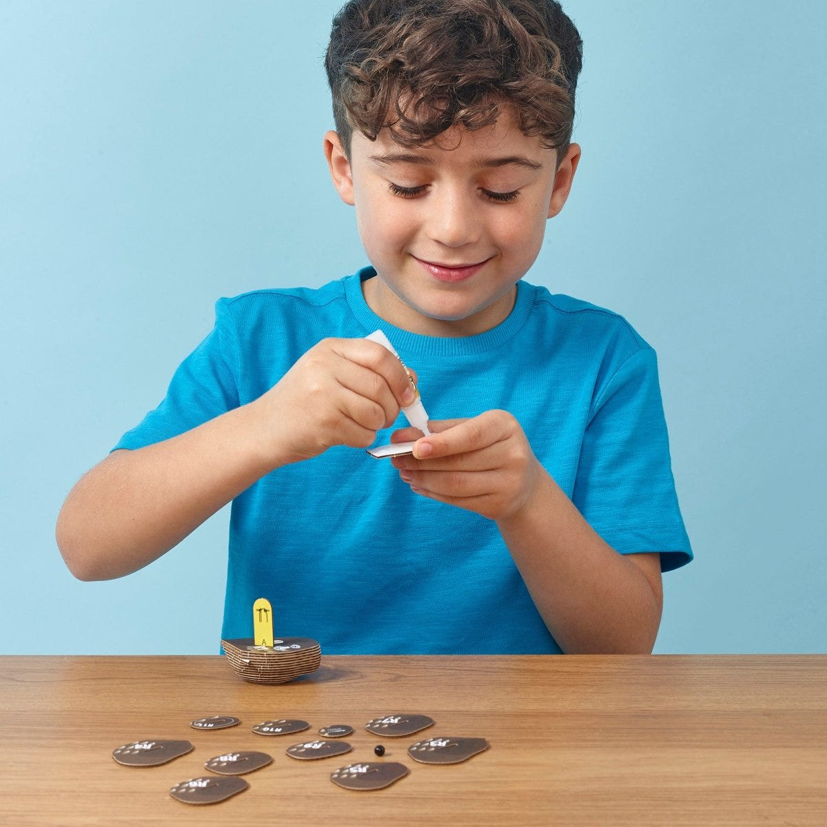EUGY Owl 3D cardboard model kit - child gluing the pieces