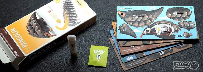 EUGY Pangolin kit contents: box, pre-cut numbered card sheets, glue and instructions