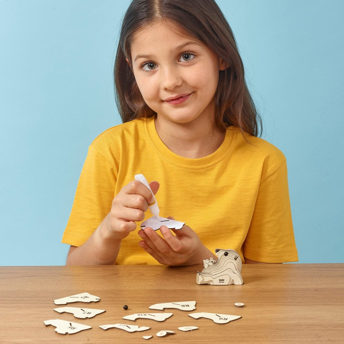 EUGY Polar Bear 3D cardboard model kit - child gluing the pieces
