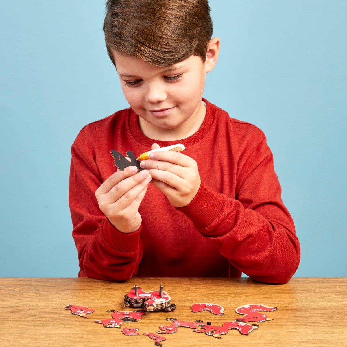 EUGY Red Dragon 3D cardboard model kit - child gluing the pieces