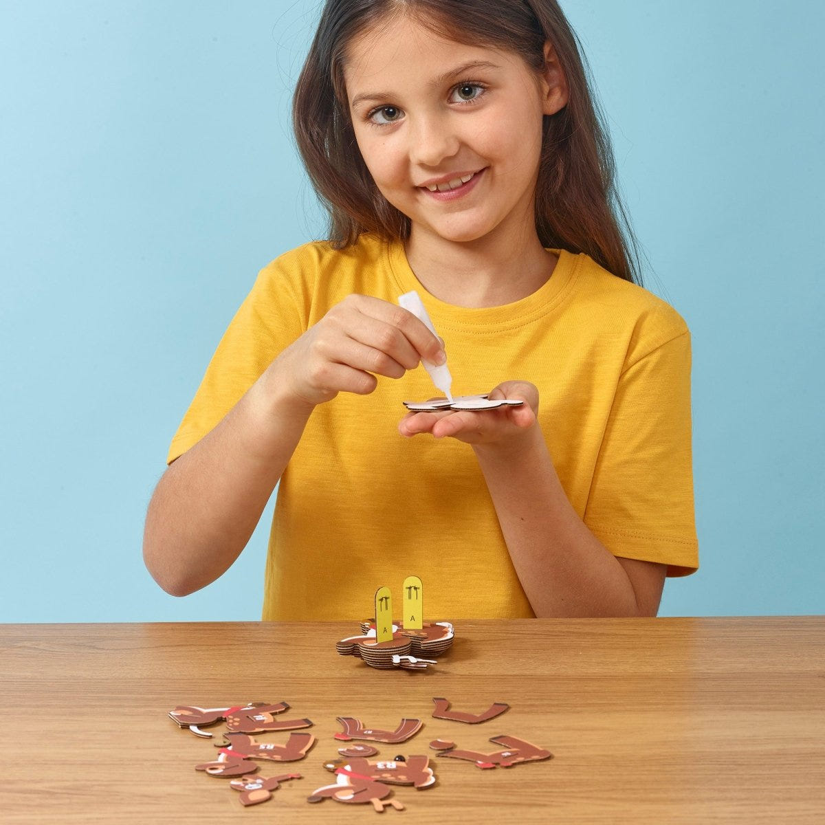 EUGY Reindeer 3D cardboard model kit - child gluing the pieces