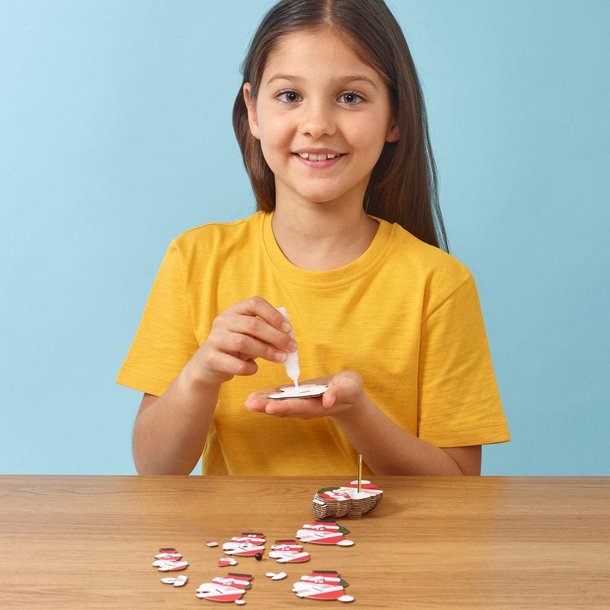 EUGY Santa 3D cardboard model kit - child gluing the pieces