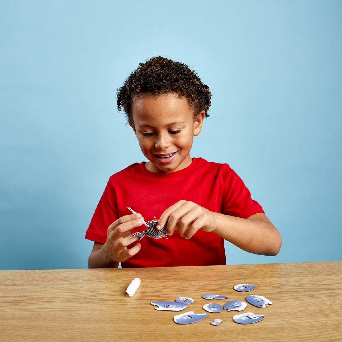 EUGY Shark 3D cardboard model kit - child assembling the model