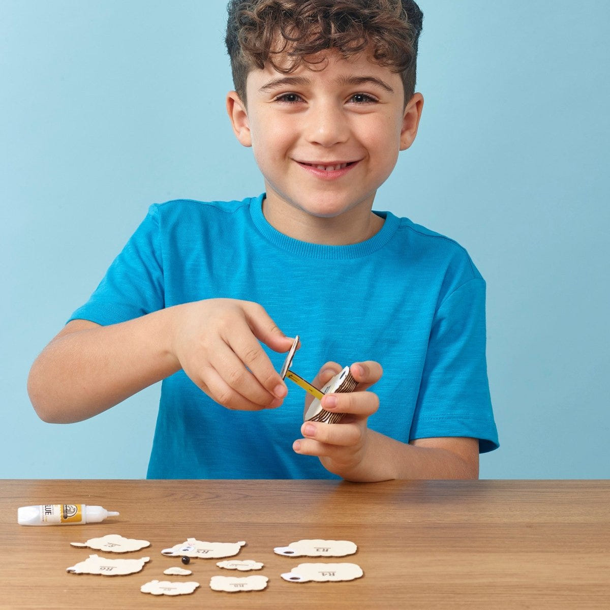 EUGY Sheep 3D cardboard model kit - child assembling the model