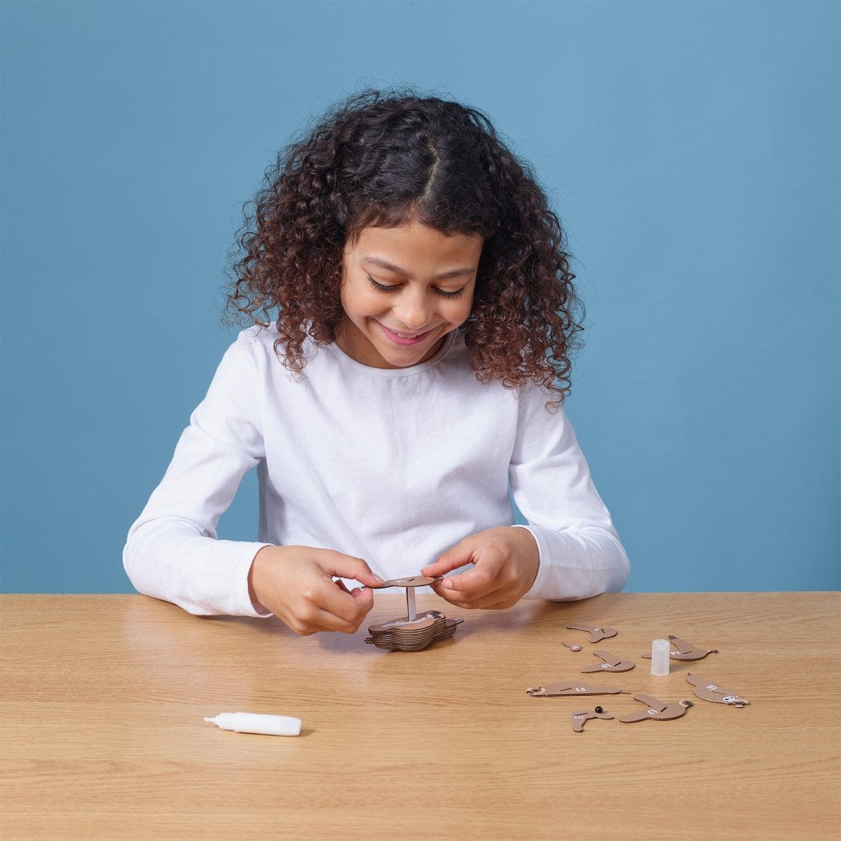 EUGY Sloth 3D cardboard model kit - child assembling the model
