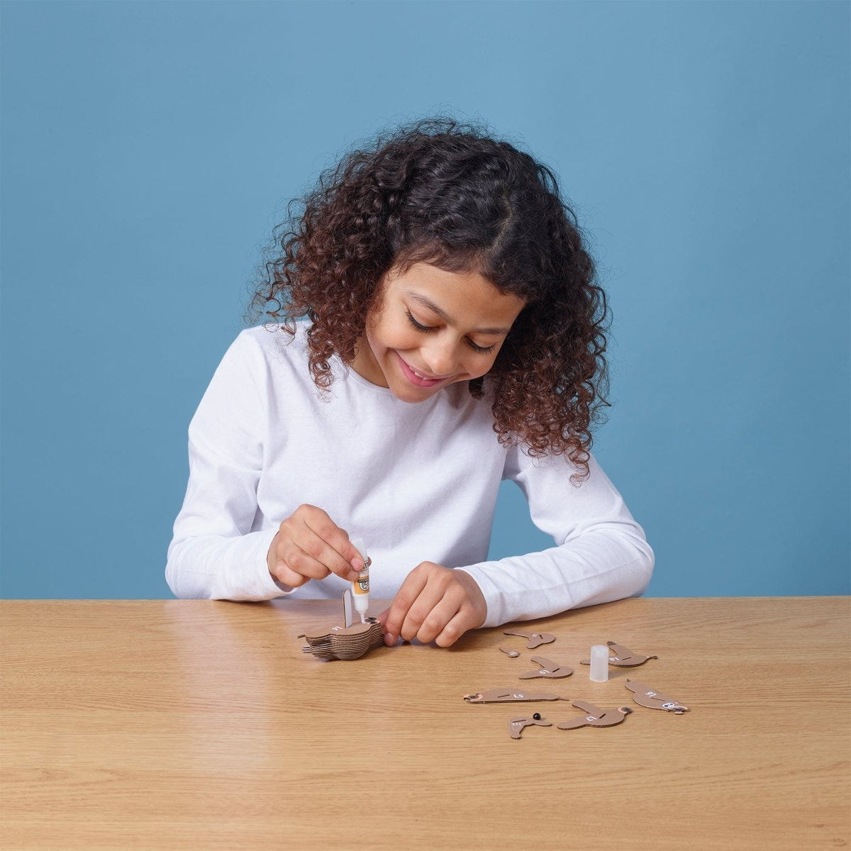 EUGY Sloth 3D cardboard model kit - child gluing the pieces