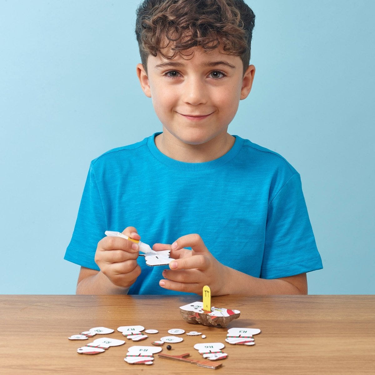 EUGY Snowman 3D cardboard model kit - child gluing the pieces