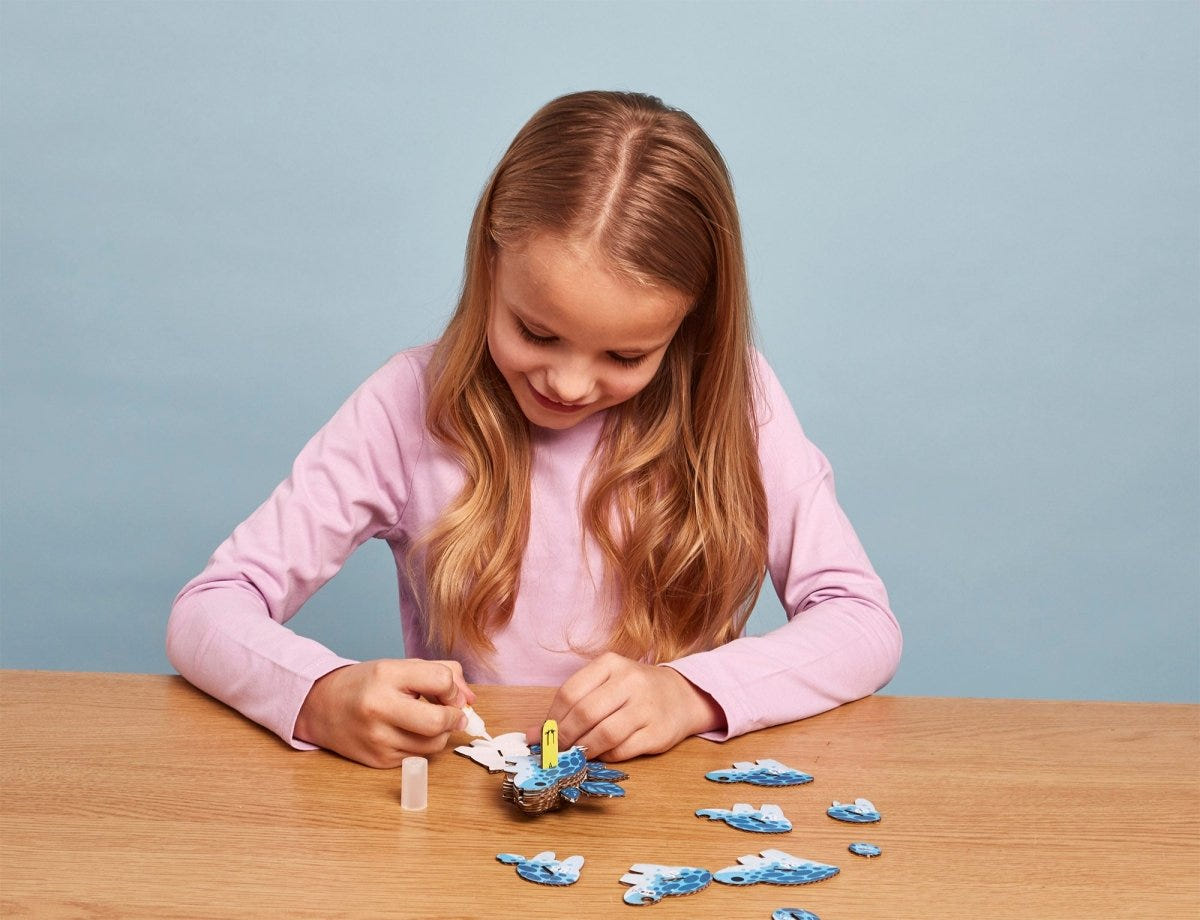 EUGY Stego 3D cardboard model kit - child gluing the pieces
