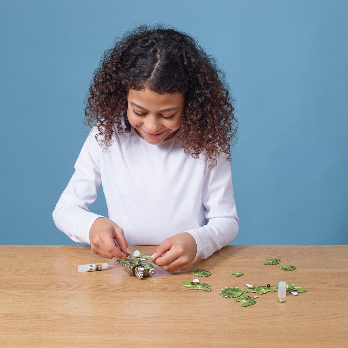 EUGY Tricera 3D cardboard model kit - child assembling the model