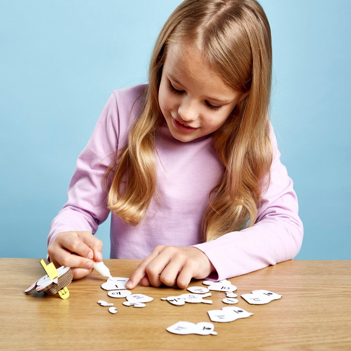 EUGY Unicorn 3D cardboard model kit - child gluing the pieces