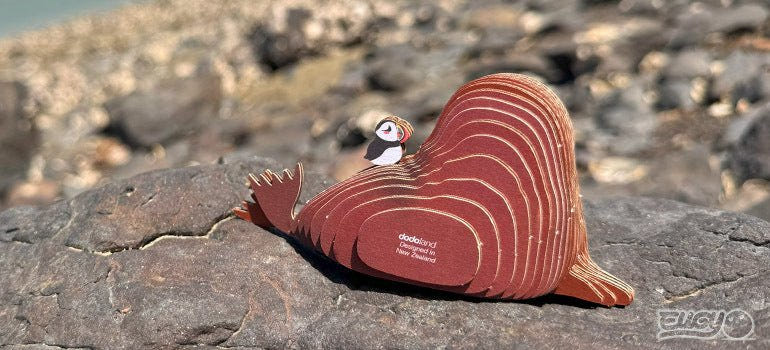 EUGY Walrus card model side view resting on a rock, puffin on its back