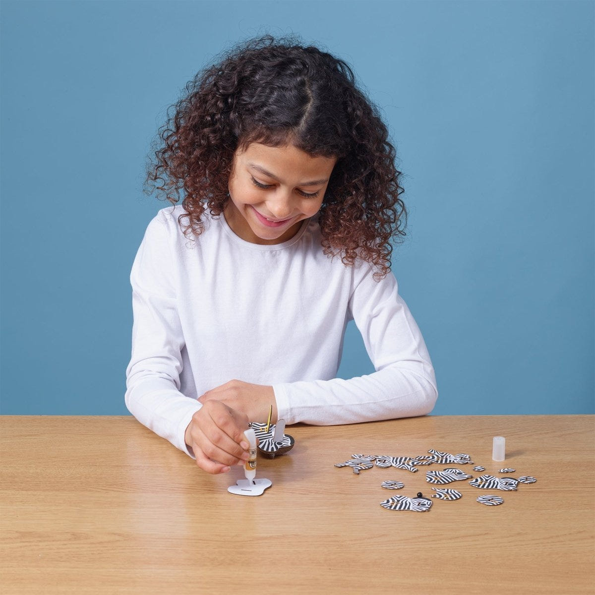 EUGY Zebra 3D cardboard model kit - child gluing the pieces