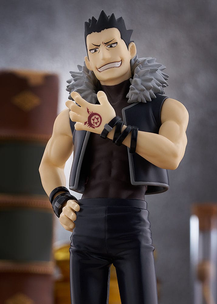 Close-up of Greed figure's grin, fur-collared vest and Ouroboros tattoo on his hand