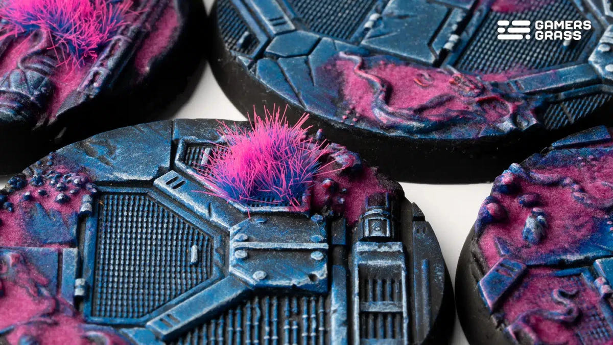 Close-up of a Gamers Grass Alien Infestation 50mm round base with a pink tuft on blue metal plating