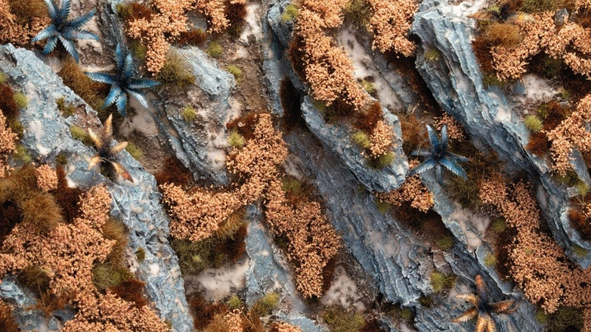 Gamers Grass Autumn Shrubs tufts on a rocky blue-grey base, shown close up in use
