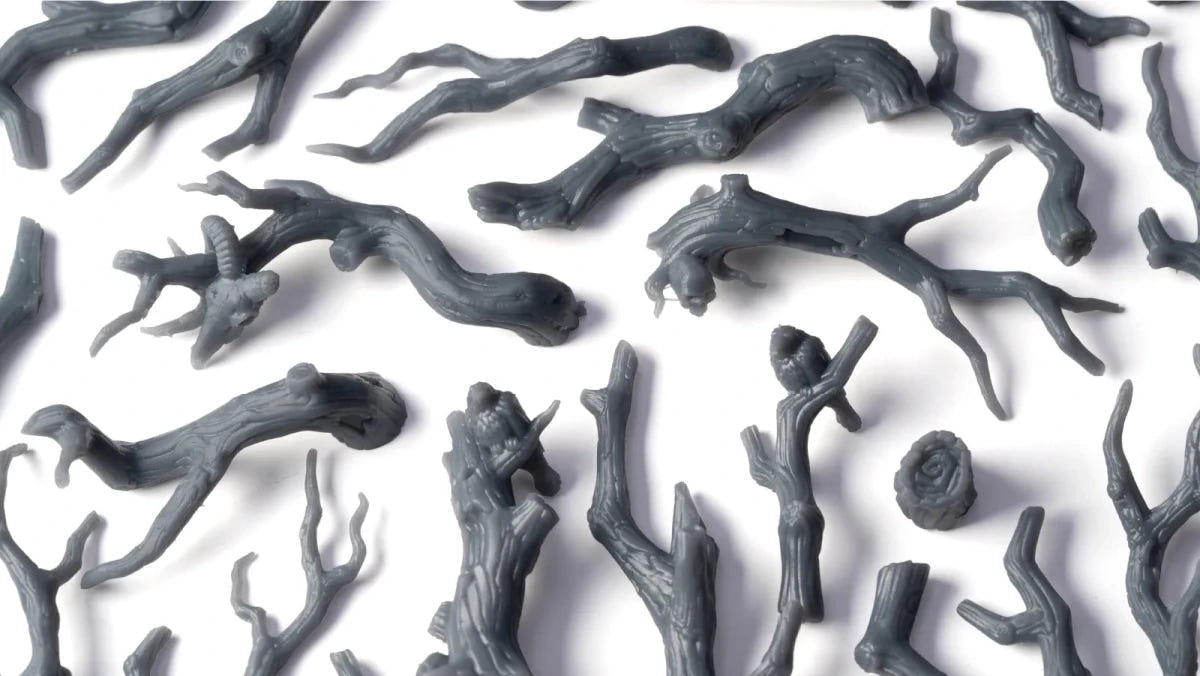 Unpainted grey resin Gamers Grass Gnarled Branches basing bits laid out on white